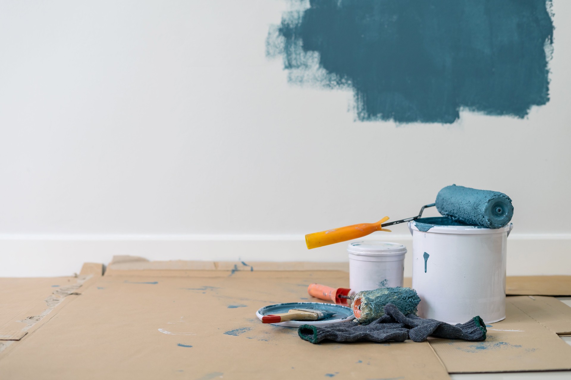 Close-Up Of Paint Roller On Container Against Wall